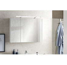 Moderner dreitüriger Badezimmer-Spiegelschrank mit integrierter LED-Beleuchtung an einer Wand über einem Waschbecken.