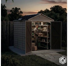 Ein Mann ordnet Kartons in einem geräumigen Kunststoff-Gartenhaus mit offenen Doppeltüren und Innenregalen während der Abenddämmerung. (Image AI modified or generated)
