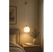 Pendelleuchte mit rundem Schirm aus mattem Glas, hängend über einem Nachttisch aus Holz in einem Schlafzimmer.