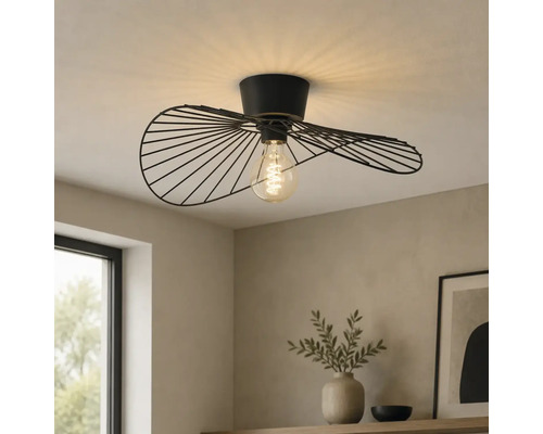 Moderne Deckenleuchte mit einem schwarzen Metalldrahtschirm in welliger Form und sichtbarem Leuchtmittel in einem hellen Raum.