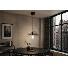 Moderne schwarze Pendelleuchte aus Metall im Drahtdesign über einem runden Esstisch in einem Zimmer mit Betonwand und Stadtblick.