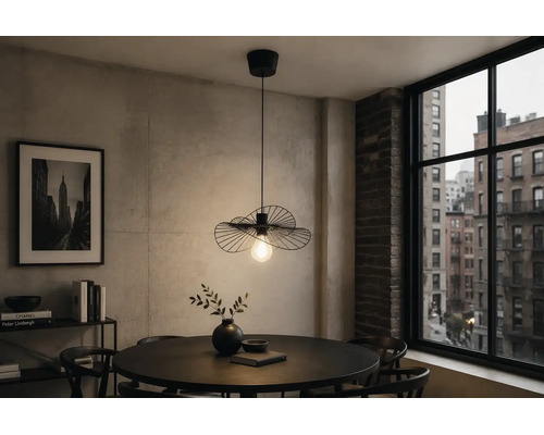 Moderne schwarze Pendelleuchte aus Metall im Drahtdesign über einem runden Esstisch in einem Zimmer mit Betonwand und Stadtblick.
