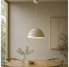 Moderne Pendelleuchte mit mehrlagigem Schirm über einem runden Esstisch aus Holz in einem hellen, minimalistisch eingerichteten Zimmer.
