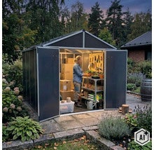 Eine Frau arbeitet in einem modernen Gartenhaus aus Kunststoff mit offener Doppeltür und Regalsystem inmitten eines grünen Gartens. (Image AI modified or generated)