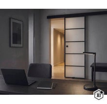 Ein Arbeitszimmer mit einem Schreibtisch, einer LED-Schreibtischlampe und einer modernen Schiebetür aus Glas mit schwarzem Rahmen. (Image AI modified or generated)