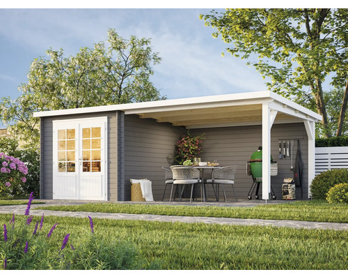 Modernes graues Gartenhaus aus Holz mit Pultdach, weißer Doppeltür und integrierter Lounge inklusive Sitzgruppe und Grill in einem Garten.
