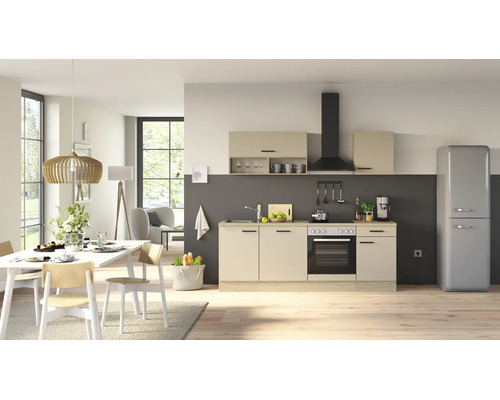 Moderne Wohnküche mit beigen Fronten, integriertem Elektroherd, Dunstabzugshaube und freistehendem Retro-Kühlschrank in offenem Wohnbereich.