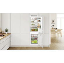 Bosch Einbaukühlschrank mit Gefrierfach in moderner Küche mit Holzfußboden und offener Tür mit Lebensmitteln.
