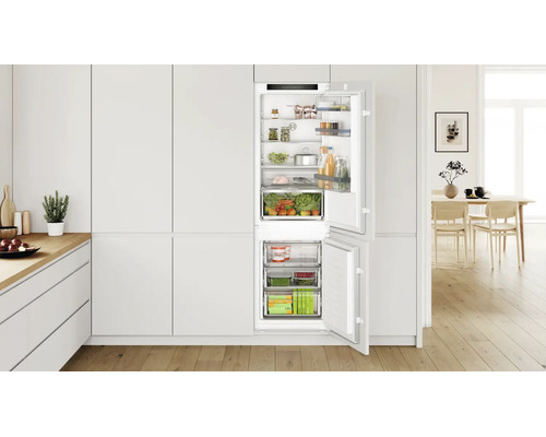 Bosch Einbaukühlschrank mit Gefrierfach in moderner Küche mit Holzfußboden und offener Tür mit Lebensmitteln.