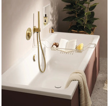 Moderne Badewanne mit goldfarbener Unterputzarmatur und Handbrause sowie einer Ablage aus Metall mit Buch und Schwamm in einem Badezimmer.