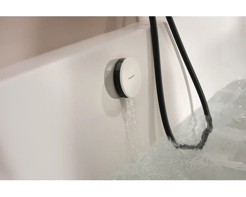 Hansgrohe Wannenfüllarmatur mit Schlauch an einer Badewanne aus dem Wasser fließt