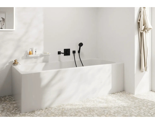 Modernes Badezimmer mit weißer Badewanne, Unterputzarmatur und Handbrause in einem Raum mit hellem Terrazzoboden und minimalistischem Design.
