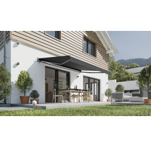 Ausgefahrene Gelenkarmmarkise über einer Terrasse mit Esstisch und Stühlen an einem modernen Einfamilienhaus.