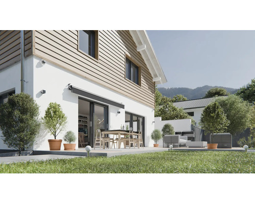 Geschlossene Kassettenmarkise in Anthrazit, montiert an einer weißen Hauswand über einer Terrassentür, mit modernem Garten und Terrassenmöbeln.