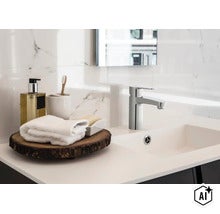 Moderne Waschbeckenarmatur aus Chrom mit Einhebelmischer auf einem Waschbecken vor einer Wand mit Marmorfliesenoptik im Badezimmer. (Image AI modified or generated)