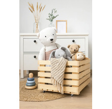 Holzkiste auf Rollen gefüllt mit Kuscheltieren in einem organisierten Kinderzimmer mit Kommode.