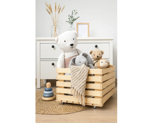 Holzkiste auf Rollen gefüllt mit Kuscheltieren in einem organisierten Kinderzimmer mit Kommode.