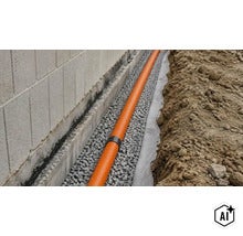Ein Drainagerohr in einem mit Kies gefüllten Graben entlang einer Hauswand zur fachgerechten Entwässerung des Gebäudefundaments. (Image AI modified or generated)