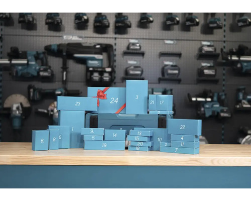 Makita Werkzeug Adventskalender mit vierundzwanzig nummerierten Geschenkschachteln auf einer Werkbank vor einer Werkzeugwand.