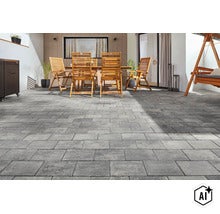 Terrasse mit Pflastersteinen in rechteckiger Verlegung vor einem Wohnhaus mit Holzmöbeln und einer Hollywoodschaukel im Außenbereich. (Image AI modified or generated)