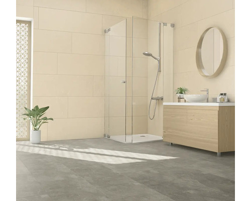 Modernes Badezimmer mit ebenerdiger Duschkabine aus Glas, Waschtisch mit Holzunterschrank und ovalem Spiegel vor hellen Wandfliesen.