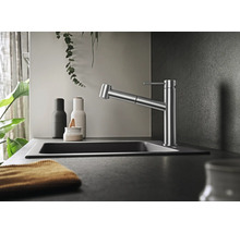 Moderne Küchenarmatur mit ausziehbarer Brause in einer eleganten Küchenumgebung mit Spülbecken und Dekorationselementen.