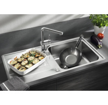 Moderne Edelstahl Küchenspüle mit integrierter Armatur, Abtropffläche und einer Auflaufform sowie einer Pfanne in einer funktionalen Küche.
