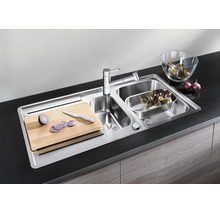 Edelstahl Einbauspüle mit zwei Becken, Armatur, Schneidebrett und Zubehör in moderner Küche.