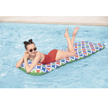 Eine junge Frau entspannt auf einer aufblasbaren Poolliege mit buntem geometrischem Muster auf dem Wasser eines Swimmingpools.
