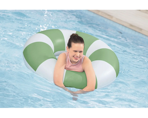 Kind spielt mit einem gestreiften aufblasbaren Schwimmring in einem Pool