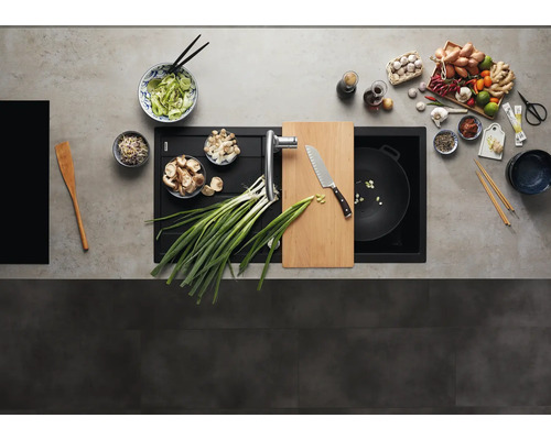 Draufsicht auf eine moderne Küchenspüle aus Verbundwerkstoff mit integriertem Schneidebrett und Küchenarmatur in einer vorbereiteten Arbeitsplatte.