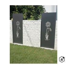 Sichtschutzelement aus Metall mit Blumenmotiv kombiniert mit einer strukturierten Mauer als Gartenbegrenzung. (Image AI modified or generated)