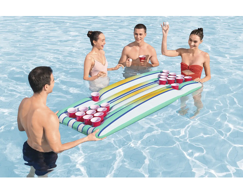 Vier Personen spielen Bierpong auf einer aufblasbaren Schwimminsel mit integrierten Becherhaltern in einem Swimmingpool.