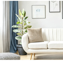 Helles Wohnzimmer mit einem modernen Sofa, einem strukturierten Kissen, einer Zimmerpflanze und Wandbildern für ein gemütliches Ambiente.