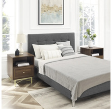 Modernes Schlafzimmer mit gepolstertem Bett, zwei Nachttischen aus Holz mit Metallbeinen und einem Teppich in einem hellen, eleganten Raum.
