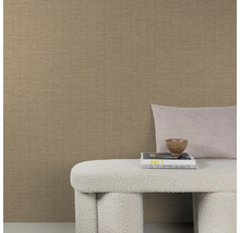 Strukturierte Vliestapete in beige mit feiner Linienoptik kombiniert mit einer Sitzbank und Dekokissen vor einer Wand.
