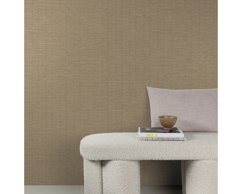 Strukturierte Vliestapete in beige mit feiner Linienoptik kombiniert mit einer Sitzbank und Dekokissen vor einer Wand.