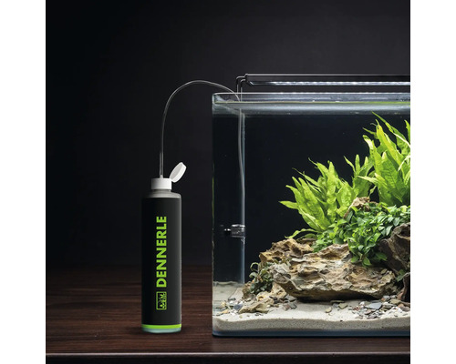 Dennerle Bio CO2 Aquarium Düngeanlage neben einem bepflanzten Aquarium mit Steinaufbau.