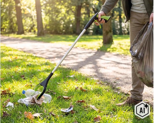 Person verwendet eine Müllgreifhilfe im Park, um eine Plastikflasche vom Boden aufzuheben und in einen Müllbeutel zu legen. (Image AI modified or generated)