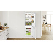 Bosch Einbaukühlschrank mit Gefrierkombination in einer modernen, hellen Küche mit Holzboden integriert.
