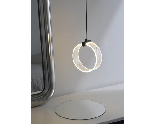 Moderne runde LED Pendelleuchte mit minimalistischem Design neben einem Spiegel auf einem Tisch