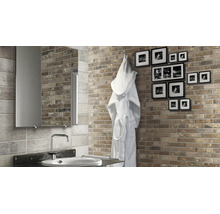 Badezimmer mit Ziegelsteinoptik Wandfliesen, Spiegel, Waschbecken und einem Bademantel an der Wand