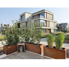 Moderne Garten Terrasse mit Pflanzkübeln aus Cortenstahl und einer Buddha Skulptur vor einer Wohnanlage mit Holzelementen.