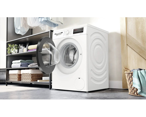 Bosch Waschmaschine mit offener Tür in einer Waschküche mit Regalen und Wäschekorb.
