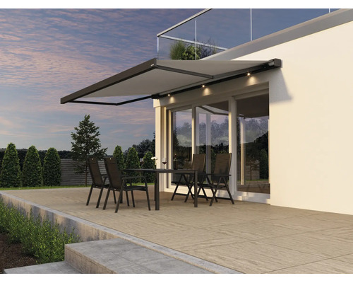 Moderne Terrassenmarkise mit integrierter LED Beleuchtung über einer Terrasse mit Sitzgruppe vor einem modernen Wohnhaus.