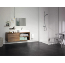 Modernes Badezimmer mit Waschtisch, Spiegel, ebenerdiger Dusche und elektrischem Durchlauferhitzer an der Wand.