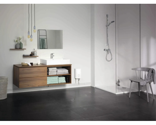 Modernes Badezimmer mit Waschtisch, Spiegel, ebenerdiger Dusche und elektrischem Durchlauferhitzer an der Wand.