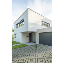 Modernes zweistöckiges Wohnhaus mit flachem Dach, integrierter Garage und gepflasterter Zufahrt mit Rasenfugen.