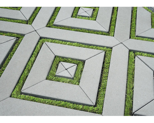 Geometrisches Pflaster aus Beton mit Rasenfugen in einem quadratischen Muster.