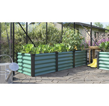 Rechteckiges Hochbeet aus Metall mit Wellenstruktur in einem Gewächshaus mit Pflanzen und Gartenutensilien auf einer Terrasse.